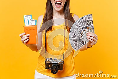 Cropped tourist woman in summer casual clothes holding bundle of dollars money, passport isolated on yellow orange Stock Photo