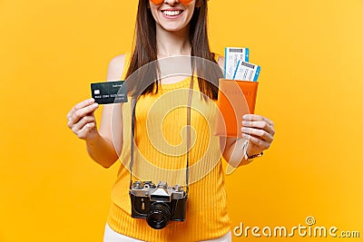 Cropped tourist woman in summer casual clothes holding credit card, passport tickets isolated on yellow orange Stock Photo