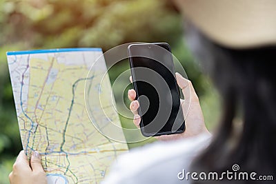 Cropped unrecognizable woman traveler using smartphone browsing on map app standing on slope of amazing landscape Stock Photo