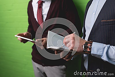 cropped view of businessmen working with digital tablet and notepad in front of Stock Photo