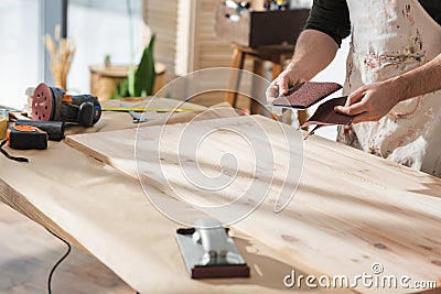 Cropped view of craftsman holding sandpaper Stock Photo