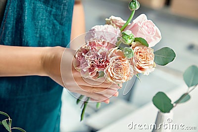 Cropped view on creative florist making flower bouquet in floral studio. Young female in workwear workplace. flower shop, business Stock Photo