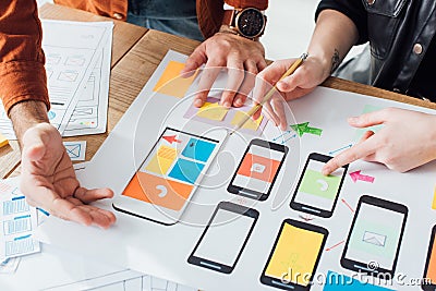 Cropped view of developers creative user experience design of mobile website with layouts on table Stock Photo