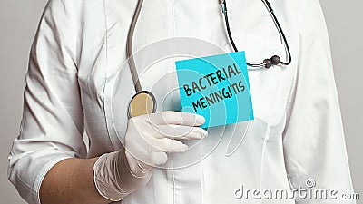 Cropped view of doctor in a white coat and sterile gloves holding a note with words - Bacterial Meningitis Stock Photo