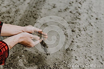 Cropped view of farmer hands pouring dry sandy soil Stock Photo