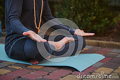 Cropped view of a man yogi in gray sportswear, sitting palms up, practicing yoga. Prayer, gratitude. Yoga hand pose. Stock Photo