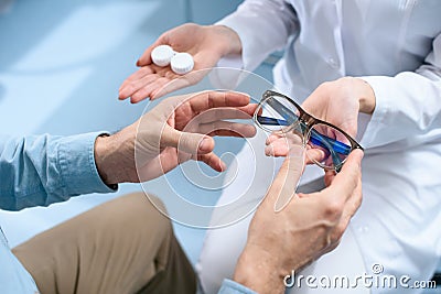 cropped view of man choosing eyeglasses or contact lenses Stock Photo