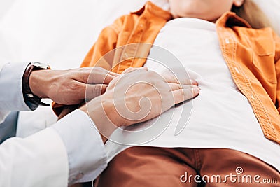 View of pediatrist in white coat examining child in clinic Stock Photo