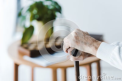 Cropped view of pensioner holding walking cane Stock Photo