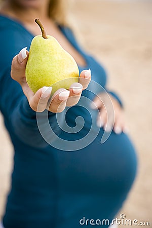 Cropped view of pregnant woman holding pear Stock Photo