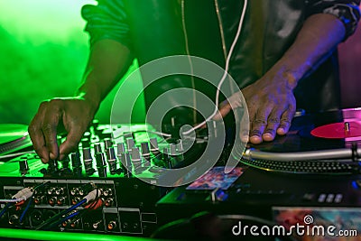 cropped view of professional african american club DJ with sound mixer Stock Photo