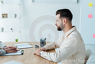 View of recruiter near handsome bearded employee Stock Photo