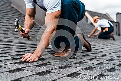 View of repairmen in uniform working on rooftop Stock Photo