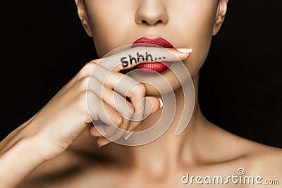 Cropped view of seductive woman with red lips showing shh symbol Stock Photo