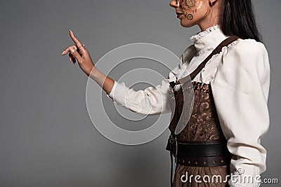 View of steampunk young woman in white blouse gesturing on grey Stock Photo