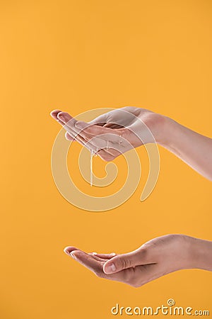 Cropped view of woman showing hands in dripping sweet honey isolated on orange. Stock Photo