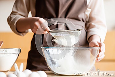 Cropped view of woman sieving flour Stock Photo