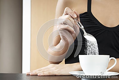 Cropped Woman Pouring Sugar In Tea Cup Stock Photo