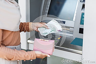 Cropped young arab lady holds a lot of euros and a wallet Stock Photo