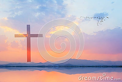 Cross against mountain and lake view at sunset Stock Photo