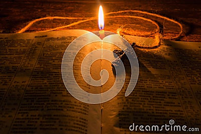 Cross on the Bible by candlelight selective focus Stock Photo