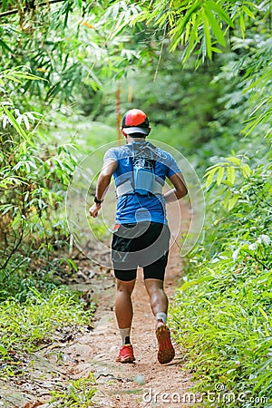 Cross country runner,Trail running in the forest,uphill in autumn trail of mud and stones,In the north of Thailand Editorial Stock Photo