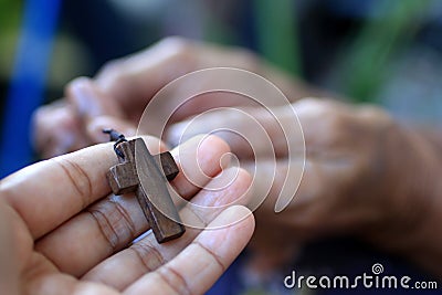 Cross in hand. Hands holding Jesus Christ holy cross crucifix. Believe in God and build a deeper relationship with God concept Stock Photo