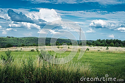 Cross on the hill. Forests, meadows and fields. A beautiful landscape. Focus on the background. KrasnobrÃ³d, Poland Stock Photo