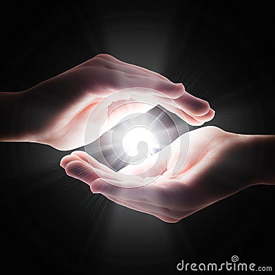 Cross light in the darkness in your hands Stock Photo