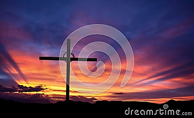 Cross silhouette on the mountain at sunset Stock Photo