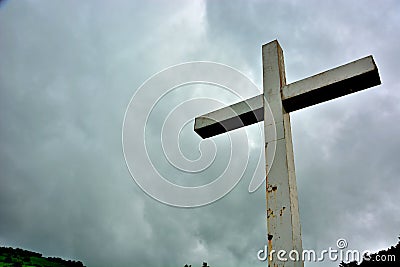 Cross situated on a hill in dramatic clouds Stock Photo
