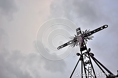 Cross situated on a hill in dramatic clouds Stock Photo