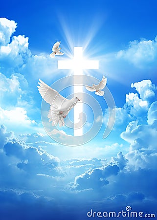 Pigeon over a cross in the cloudy sky background with light rays Stock Photo