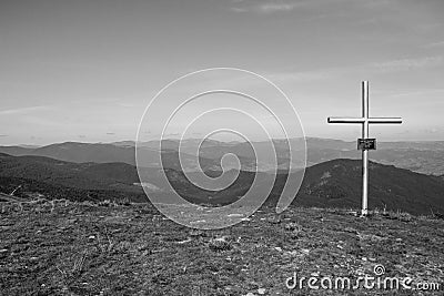 Cross on the top of mountains black and white. Faith and memory sign.Christian religion symbol monochrome. Road to nowhere. Stock Photo