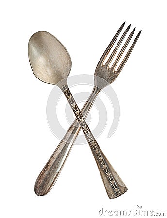 Crossed vintage spoon and fork isolated on bell background. Rustic style Stock Photo