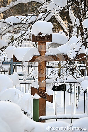 Crosses in a cemetery, monuments of the dead, a cemetery in winter, wreaths, artificial flowers. Russia Stock Photo