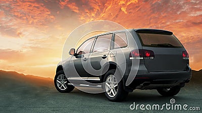 Crossover SUV in the hillside with sunset in the background. Stock Photo