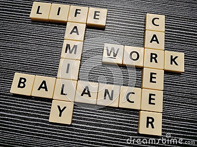 Crossword life family balance work career made from square letter tiles against black background. Stock Photo