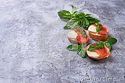 Crostini with salmon, mozarella, tomato and basil Stock Photo