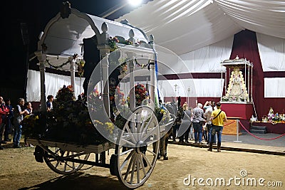 Crowd with donkey and a cart in front of the icon of virgin of Rocio during pilgrimage Editorial Stock Photo