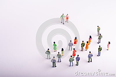 The crowd looks at the man and woman who comes towards her on a white background. A man and a woman are approaching a group Stock Photo