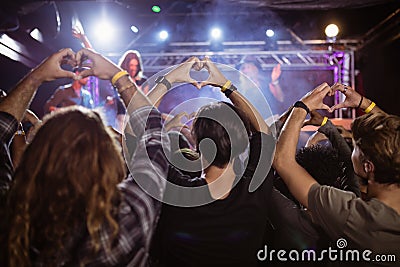 Crowd making heart shape with hands during performance Stock Photo