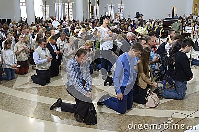 Crowd of parishioners kneeling and praying in a church Editorial Stock Photo