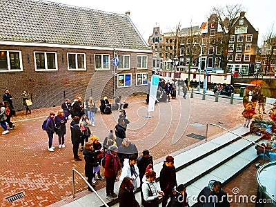 Crowd of people of acculturated tourists lining up to visit the Anna Frank house building and Amsterdam museum in winter Editorial Stock Photo