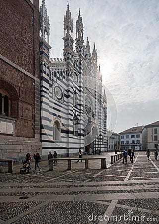 Crowd of people ambling past the towering Monza Cathedral on a sunny day. Italy. Editorial Stock Photo