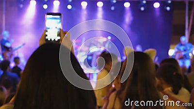 Crowd of people at a concert. Young people enjoy live music show, excited fans take pleasure in concert and applaud to popular band, perform a favorite song stock video footage Crowd of people at a concert. Young people enjoy live music show, excited fans take pleasure in concert and applaud to popular band, perform a favorite song stock video footage