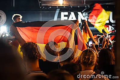 Crowd of people holding German flags during a celebration event at night Editorial Stock Photo