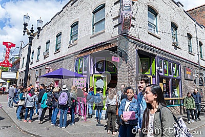 A crowd of people lines up outside famous Voodoo Donuts in downtown Portland Editorial Stock Photo