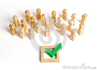 A crowd of people looks at a green check mark. Voting and election concept. Referendum, revolution. Forcible overthrow. Stock Photo