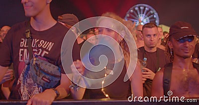 A crowd of people in the night dancing on the dance floor of the festival. Editorial Stock Photo